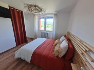 a bedroom with a bed with a red and white blanket at L'Oustal Roja in Saint-Affrique