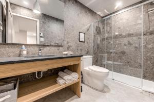 a bathroom with a toilet and a glass shower at 77 St-Vallier Apparts Hôtel in Quebec City +166 photos