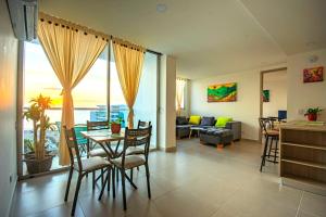 un salon avec une table, des chaises et un canapé dans l'établissement Exclusivo apartamento en Cielo Mar-playa las Americas, con maravillosas vistas del atardecer de Cartagena, à Carthagène des Indes