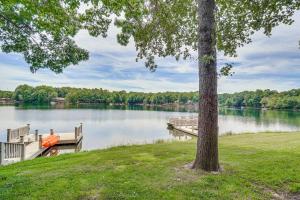 a man in a boat on a dock on a lake at Lakefront Crossville Condo - Fish, Boat and Golf! in Fairfield Glade