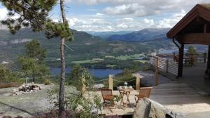 a deck with a table and chairs and a view of a lake at Weitblicken - Cosy Holiday Home with stunning views in Vradal