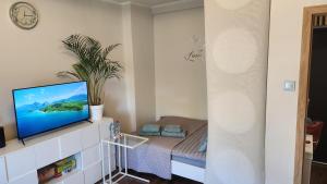 a living room with a flat screen tv on a white cabinet at Słoneczne Mieszkanko Przymorze 2 km do plaży in Gdańsk