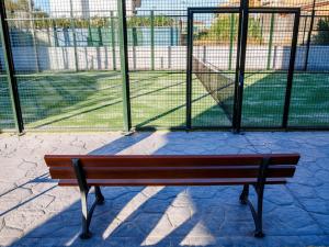 a wooden bench sitting in front of a fence at Apartamento Playa de Punta Candor in Rota