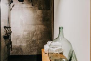 a glass bottle sitting on a table in a bathroom at Casa do Corral in Hospital