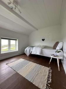 a bedroom with a bed and a table and a rug at Sjønært småbruk in Bud