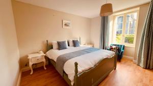 Un dormitorio con una cama grande y una ventana. en Brittany Carantec Morlaix, en Saint-Martin-des-Champs