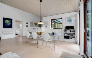 a dining room with a table and white chairs at Three-Bedroom Holiday Home In Albak in Ålbæk +15 photos