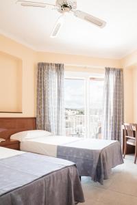 a hotel room with two beds and a window at Hotel Golf Beach in Santa Ponsa