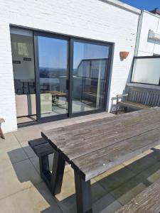 a wooden bench sitting on top of a patio at zonnig vernieuwd penthouse dicht bij het strand in Knokke-Heist