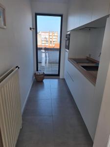 a hallway leading to a kitchen with a view at zonnig vernieuwd penthouse dicht bij het strand in Knokke-Heist +9 photos