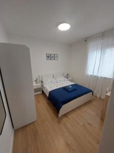 a bedroom with a bed in a white room at Apartman Zlata in Pakoštane