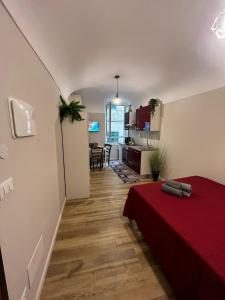 una camera con letto rosso e cucina di La casa di Marge a Sanremo