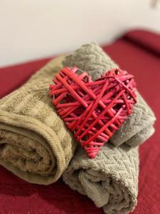 un cuore rosso appoggiato su una pila di asciugamani di La casa di Marge a Sanremo