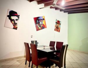 a dining room table with chairs and pictures on the wall at San Quintin Casa Skov in Los Pinos +9 photos