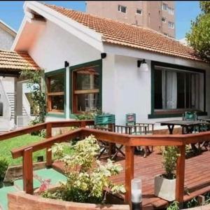 eine Holzterrasse mit einem Picknicktisch und einem Haus in der Unterkunft Departamentos Momo in San Bernardo