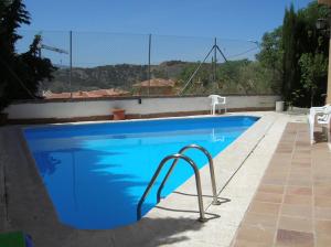 una piscina azul con una barra de metal al lado en Casa Ghalia, en Cenes de la Vega