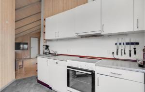 eine Küche mit weißen Schränken und einem Herd mit Backofen in der Unterkunft 3 Bedroom Cozy Home In Højslev in Højslev
