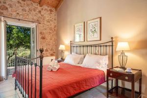 a bedroom with a bed with a red bedspread and a window at Villa Hlazeika by Villa Plus in Old Skala +33 photos