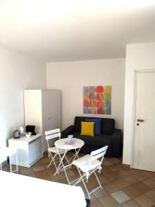 Una sala de estar con un sofá, una mesa y sillas. en I POGGI SUL GOLFO, en La Spezia