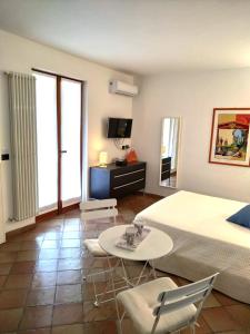 Un dormitorio con una cama y una mesa y sillas. en I POGGI SUL GOLFO, en La Spezia