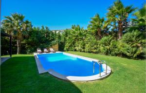 a swimming pool in a yard with chairs and trees at Stunning Home In Finikia in Foinikiá +16 photos