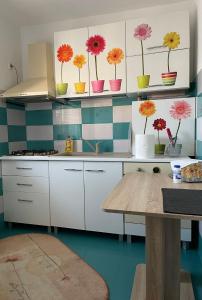 eine Küche mit bunten Blumen auf den Regalen in der Unterkunft Apartament Natalia in Vama Veche