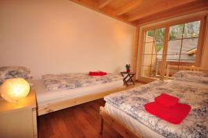 ein Schlafzimmer mit 2 Betten und roten Handtüchern darauf in der Unterkunft Luxury Penthouse Apartment in Lauterbrunnen