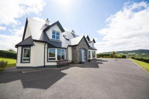 a white house with a black roof on a driveway at Farnaught House in Westport