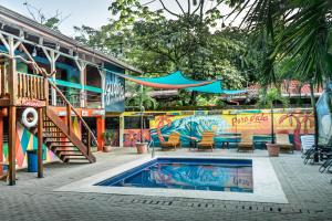 a swimming pool with chairs and a staircase next to a building at Blue Iguana in Sámara