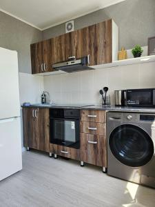 een keuken met wasmachine en droger bij Квартира-студия рядом с Набережной in Balqash