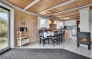 a kitchen and dining room with a table and a stove at Lovely Home In Vejers Strand With Sauna in Vejers Strand