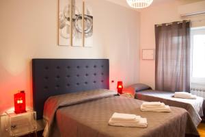 羅馬的住宿－皮格尼托公寓，一间卧室设有两张床和两个红色蜡烛