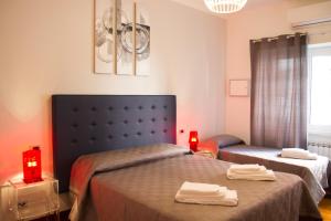a bedroom with two beds and two red candles at La Casa Del Pigneto in Rome
