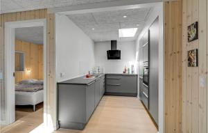 a kitchen with a black counter and a room with a bed at Holiday Home Fyrgården Blåvand in Blåvand
