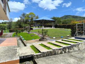 un jardín con mesa y sombrilla en Finca Hotel Posada La Riviera, en Moniquirá 8 fotos más