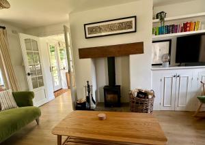 een woonkamer met een open haard en een salontafel bij Holly Cottage in Cirencester