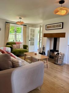 een woonkamer met een bank en een tafel bij Holly Cottage in Cirencester