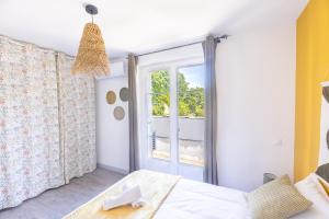 una camera da letto con un letto e una finestra di Le Botanique "By Cottage d'Auch" ad Auch