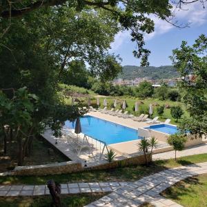 a swimming pool with lounge chairs and umbrellas at Green Hill Apartments in Ulcinj