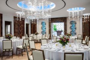 a banquet room with white tables and chairs and a chandelier at Costa d'Este Beach Resort & Spa in Vero Beach +131 photos