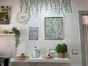 a kitchen counter with a clock and a shelf with two cups at Casa D' alao in Santiago de la Ribera