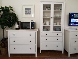 巴德小基希海姆Alpenglück - Ferienwohnung的一个白色的梳妆台，配有两个白色的橱柜和一台电视 更多13张照片