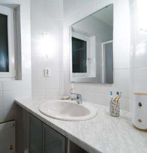 a white bathroom with a sink and a mirror at Alpenglück - Ferienwohnung in Bad Kleinkirchheim