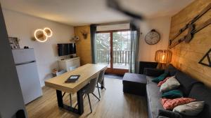 a living room with a couch and a table at Appartement 4 à 6 personnes - Chalets d'Aurouze - La Joue du Loup in Le Dévoluy