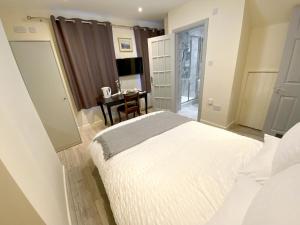 アリスバーリーにあるApartment with an Open-Plan Kitchen Living Roomの大きな白いベッドとテーブルのある寝室