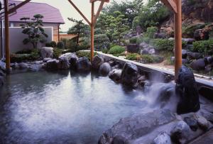 un estanque en un jardín con rocas y agua en Misakitei en Kami Amakusa