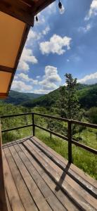 a wooden porch with a view of the mountains at AЖ у НЕБІ in Vizhenka