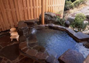 a small pool of water with a stone wall at Misakitei in Kami Amakusa