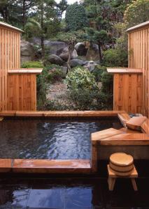 una piscina con terrazza in legno e un laghetto con servizi igienici di Misakitei a Kami Amakusa