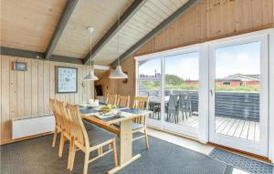 a dining room with a table and chairs on a deck at Amazing Home In Hvide Sande With Wifi in Bjerregård